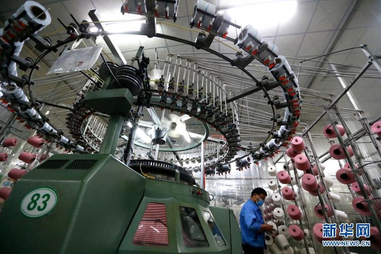 5月5日,在青岛市即墨区的青岛颐和针织生产车间,纺织工人在