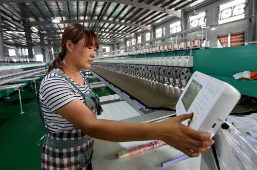 8月23日,在河南省汝州市百瑞纺织品,一位工人在生产线上作业.